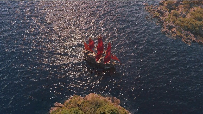 ship with red sails on water