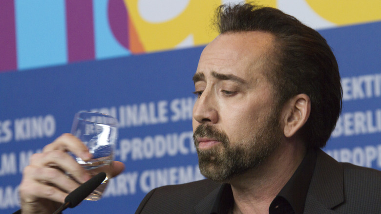 Nicolas Cage staring at glass of water