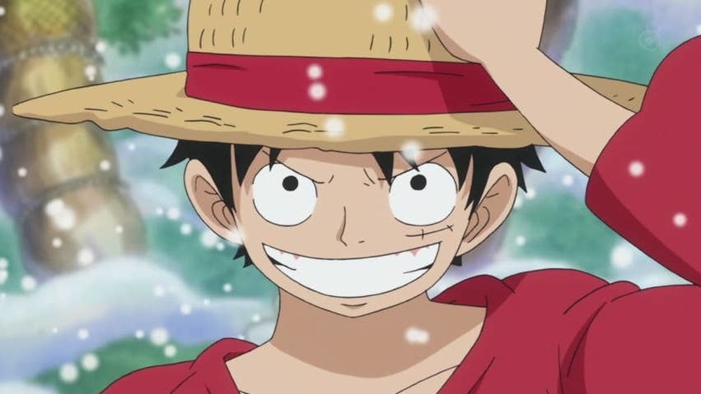 Luffy grinning and holding onto hat