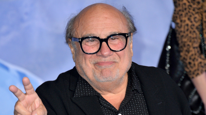 Danny DeVito holding up peace sign