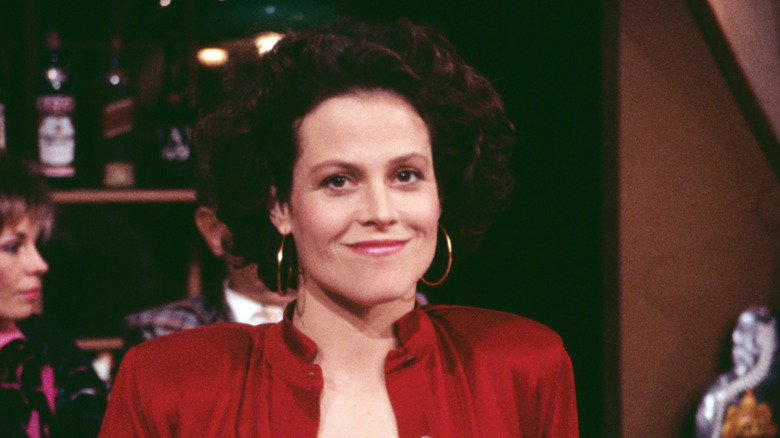 Sigourney Weaver smiling in a red dress