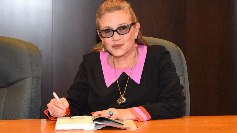 Carrie Fisher signing a book