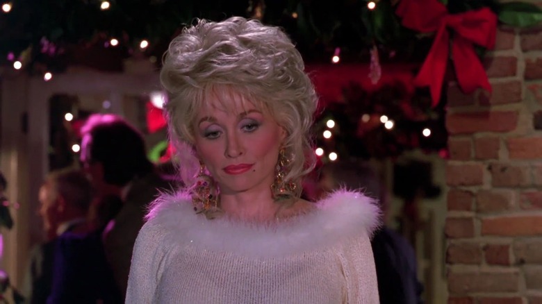 Dolly Parton standing in white cashmere sweater 