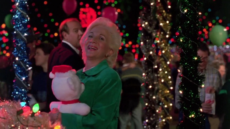 Dukakis holding stuffed bear in front of Christmas lights 