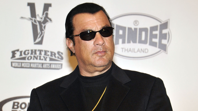 Steven Seagal scowling with sunglasses on