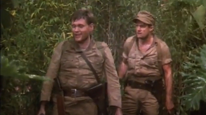 Soldiers walk through jungle