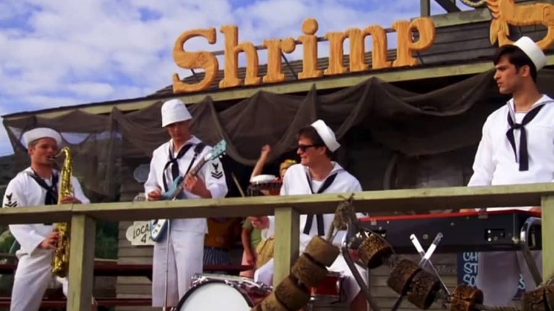 Four band members dressed in sailors garb playing instruments