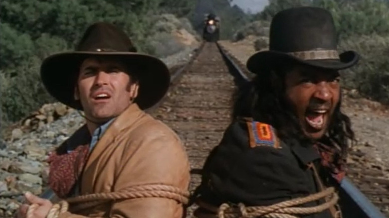 Brisco and Lord Bowler lashed to train tracks