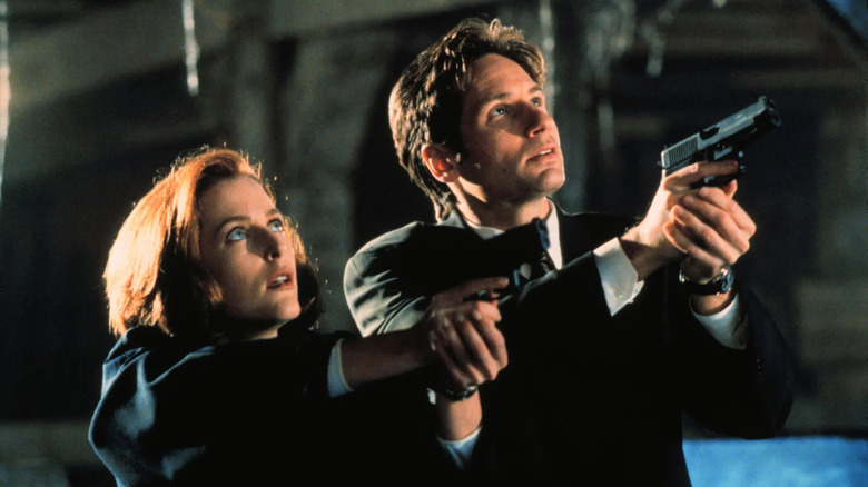 Mulder and Scully look up and aim their guns