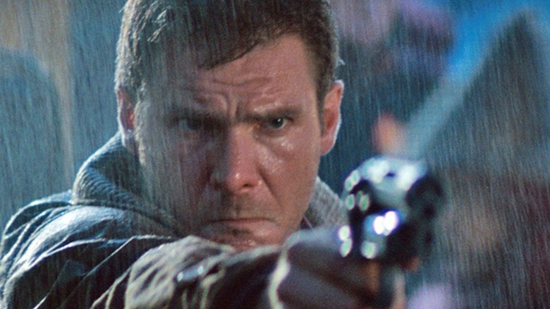 Deckard points gun in rain