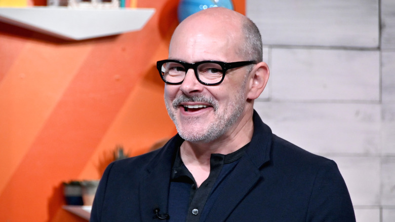 Rob Corddry smiling wearing glasses