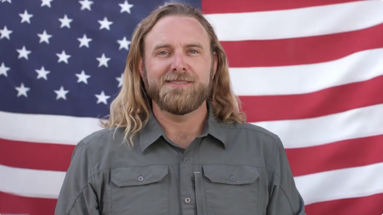 James Schrader in front of a flag