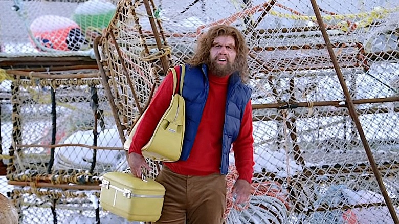 Geico Caveman holding fancy luggage