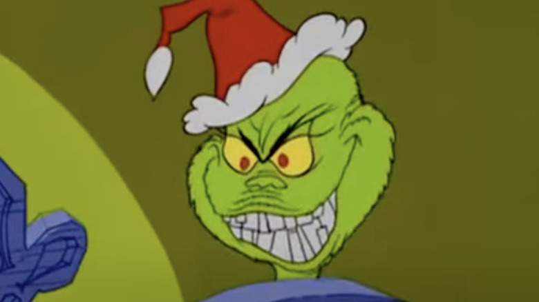 The Grinch in Santa hat, grinning