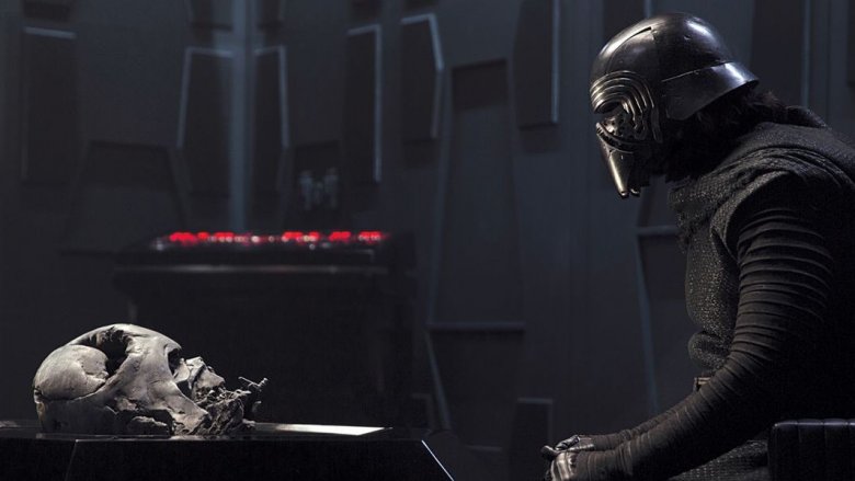 Adam Driver as Kylo Ren staring at Darth Vader's melted helmet in "Star Wars: Episode VII — The Force Awakens"