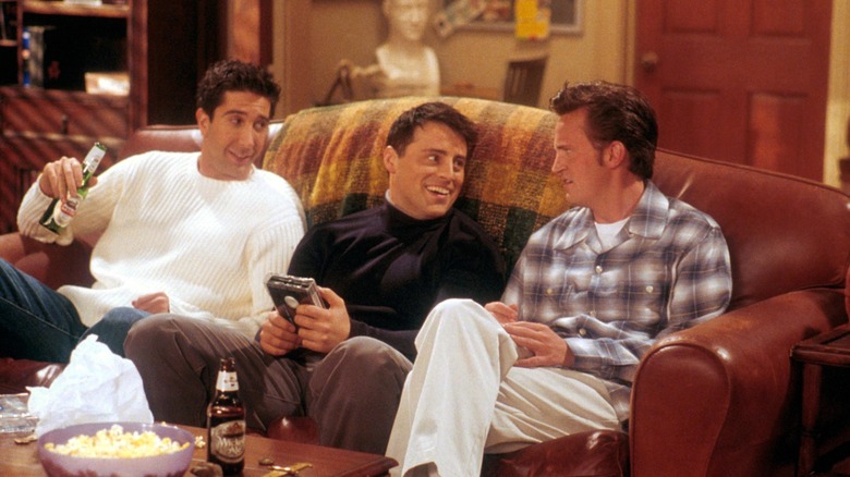 Ross, Joey, and Chandler sit on the couch