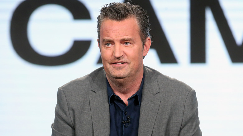 Matthew Perry smirks