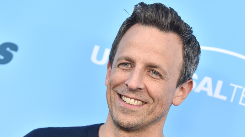 Seth Meyers grinning at press