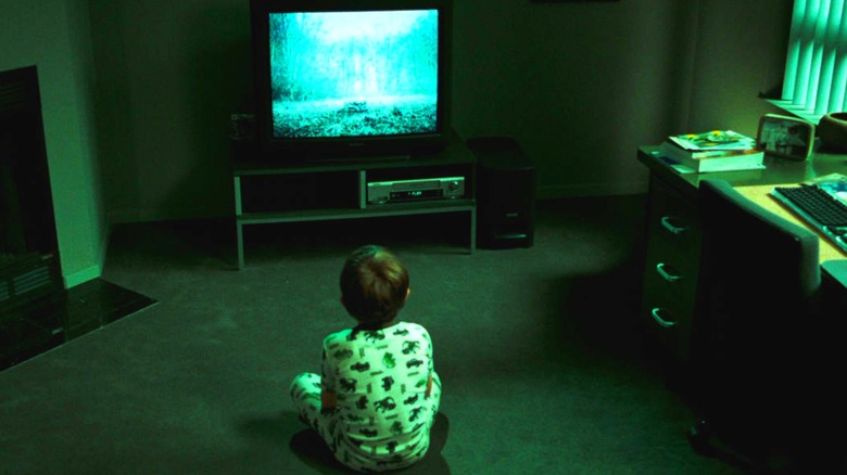 Aiden sits in front of a TV displaying Samara's eerie well