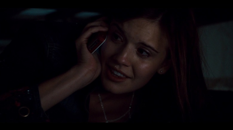 Maggie Grace talking on the phone under a bed