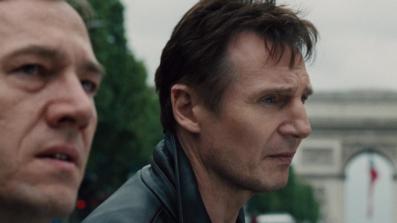 Liam Neeson in front of the Arc de Triomphe talking to a friend