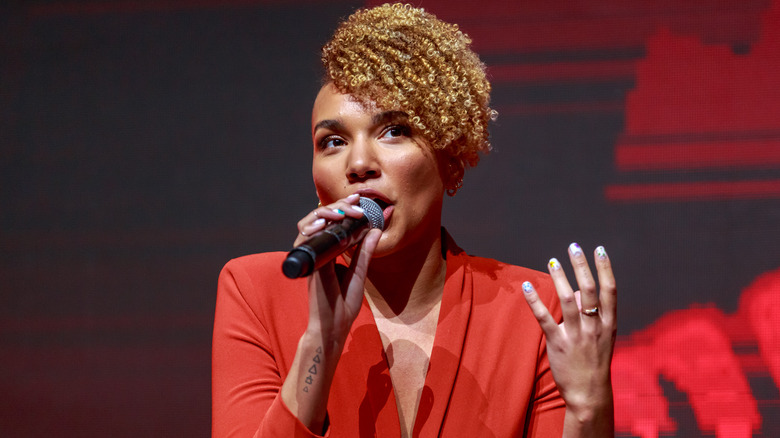 Emmy Raver-Lampman sitting and talking into microphone