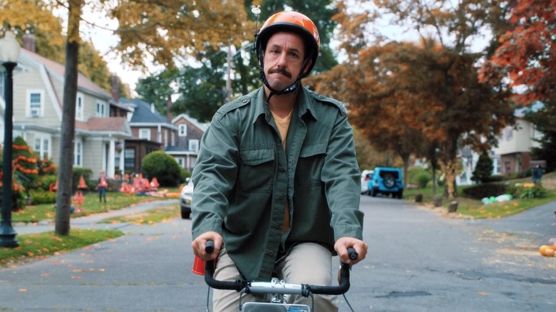 Adam Sandler on a bike in autumn