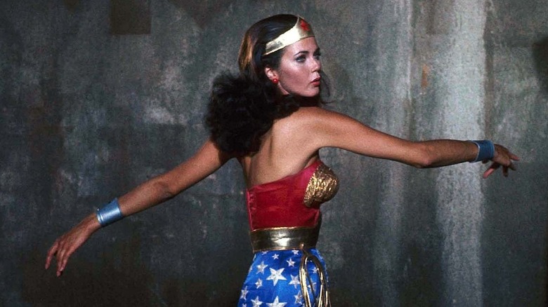 Wonder Woman spins in front of dark wall