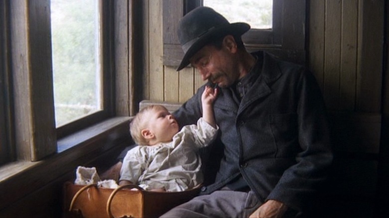 Daniel Plainview holds baby H.W.