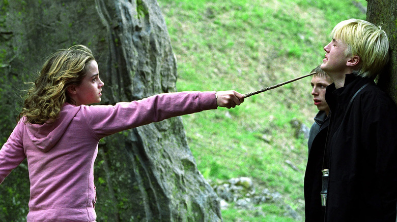 Hermione holding Draco at wandpoint