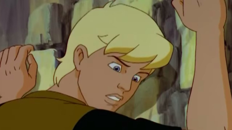 Jonny Quest hangs onto a cliff face