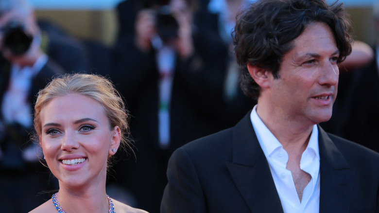 Scarlett Johansson and Jonathan Glazer smile in opposite directions