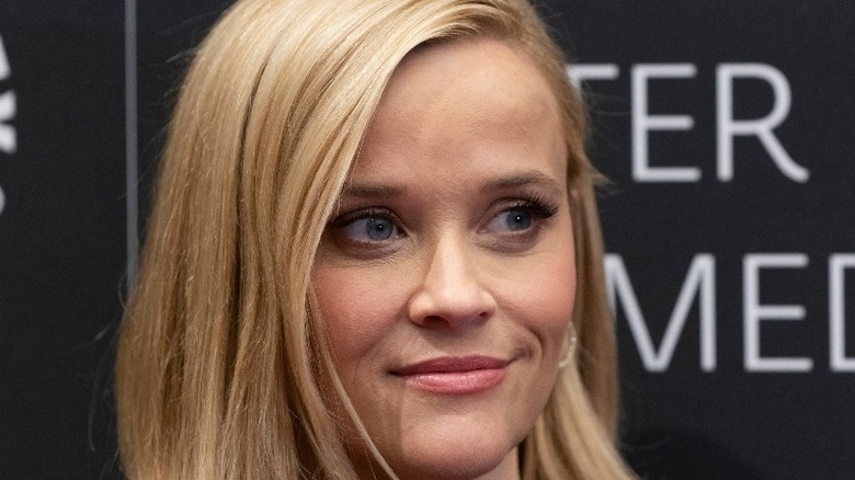 Reese Witherspoon smiles looks left