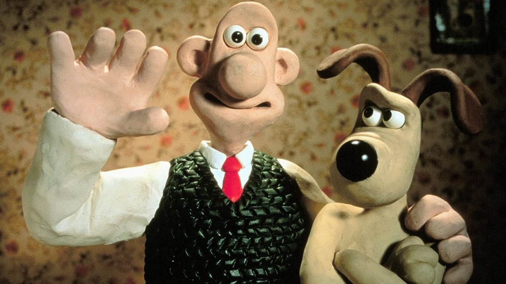 Wallace waving and Gromit scowling