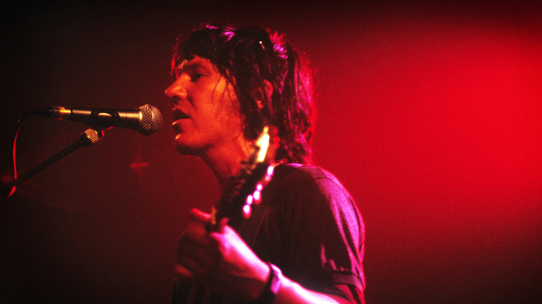 Elliot Smith singing and playing guitar