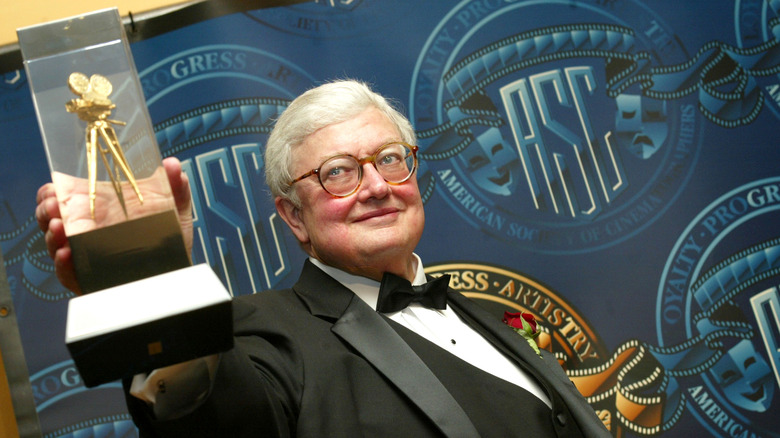 Roger Ebert clutching an award