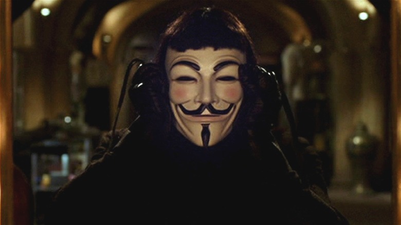 V putting on a Guy Fawkes mask in V for Vendetta (2005)