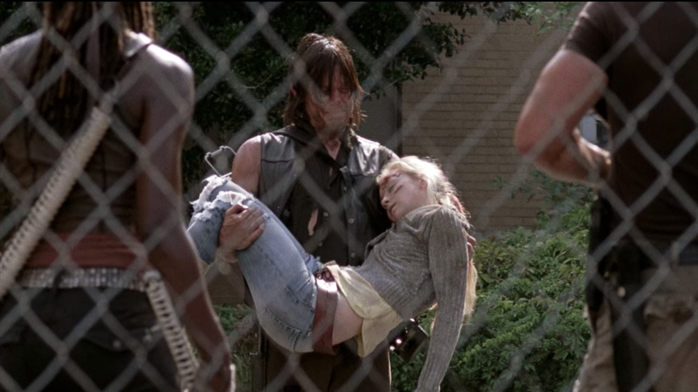 Daryl carries Beth's body in his arms.