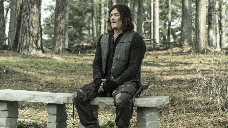 Reedus sitting on a bench