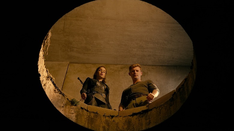 Ava and Michael peer into hole, look tiny