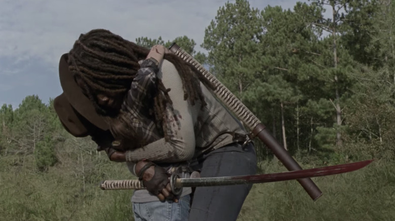 Michonne hugs Judith with sword