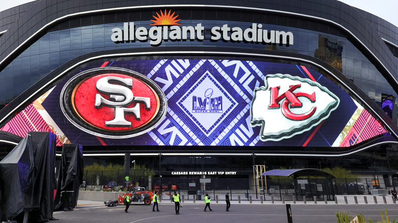 Workers walk in front of Allegiant Stadium