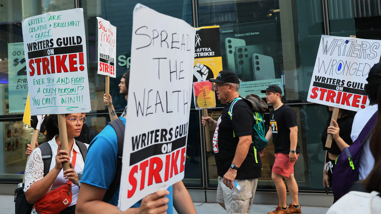 Writers holding signs on strike