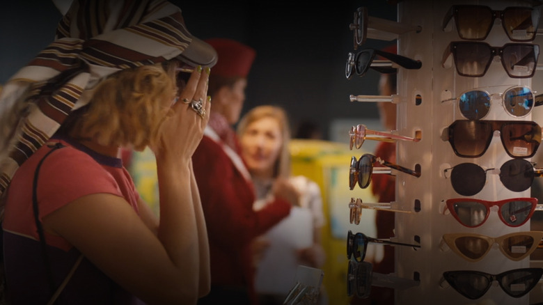 POrtia trying on sunglasses in airport