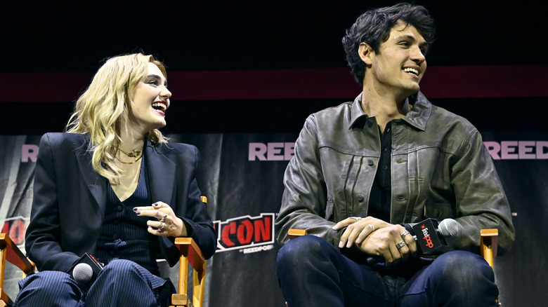 Meg Donnelly and Drage Rodger sitting side by side on a convention stage