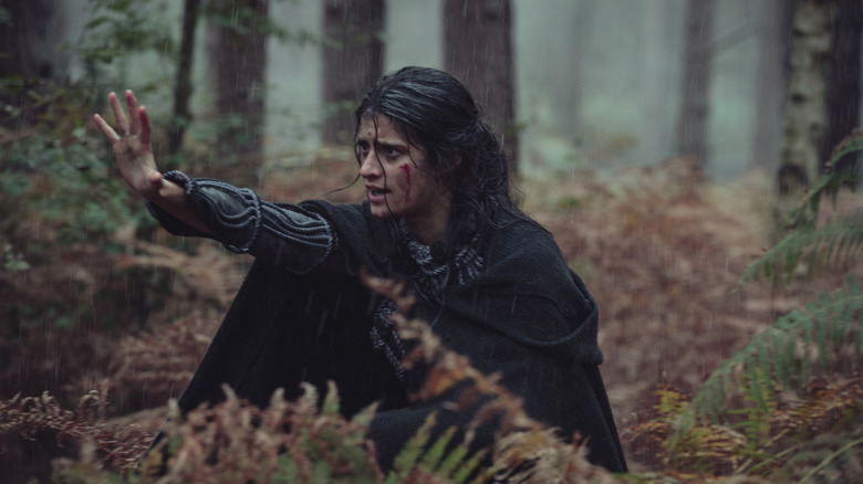 Yennefer extending arm in forest