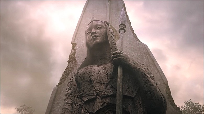 A stone statue of a woman holding a spear