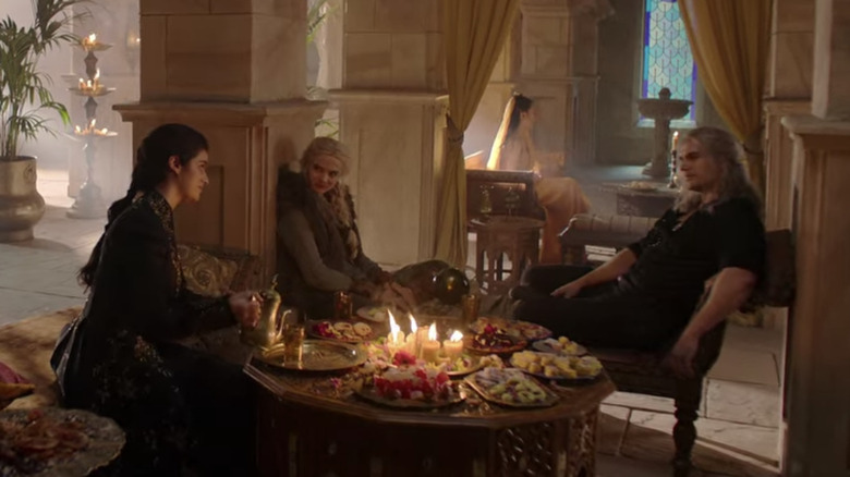 Ciri, Yennefer, and Geralt at a table