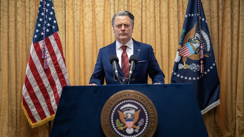 the unnamed president from a24's civil war gives a speech at a presidential podium