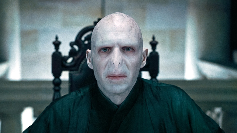 Ralph Fiennes Voldemort seated staring 